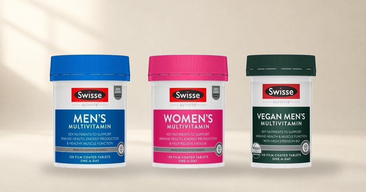Three Swisse Ultivite multivitamin bottles standing on a cream studio floor, the men's, women's and vegan versions side by side